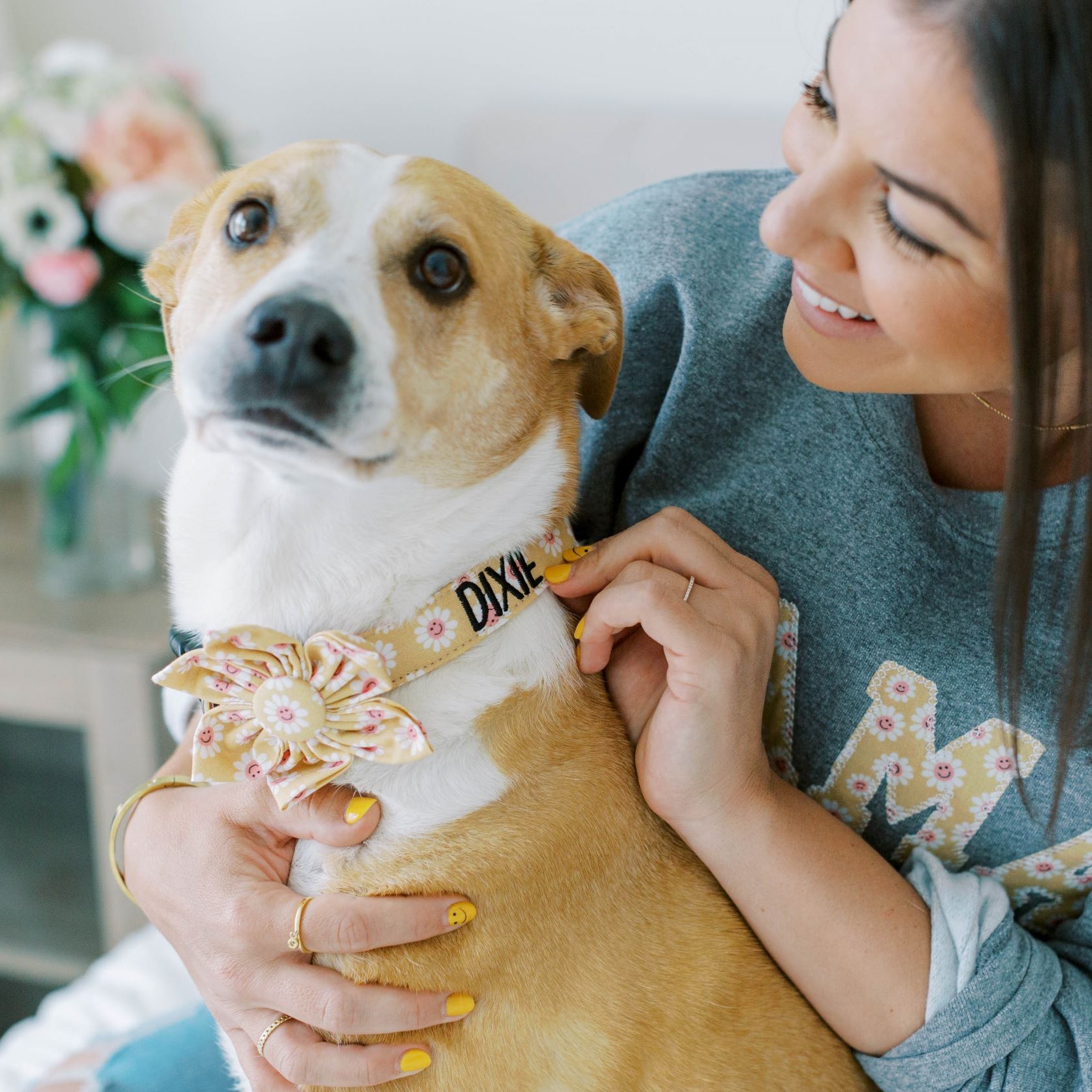 Model wearing dog mom sweatshirt with her dog in a matching personalized dog collar with flower collar accessory.