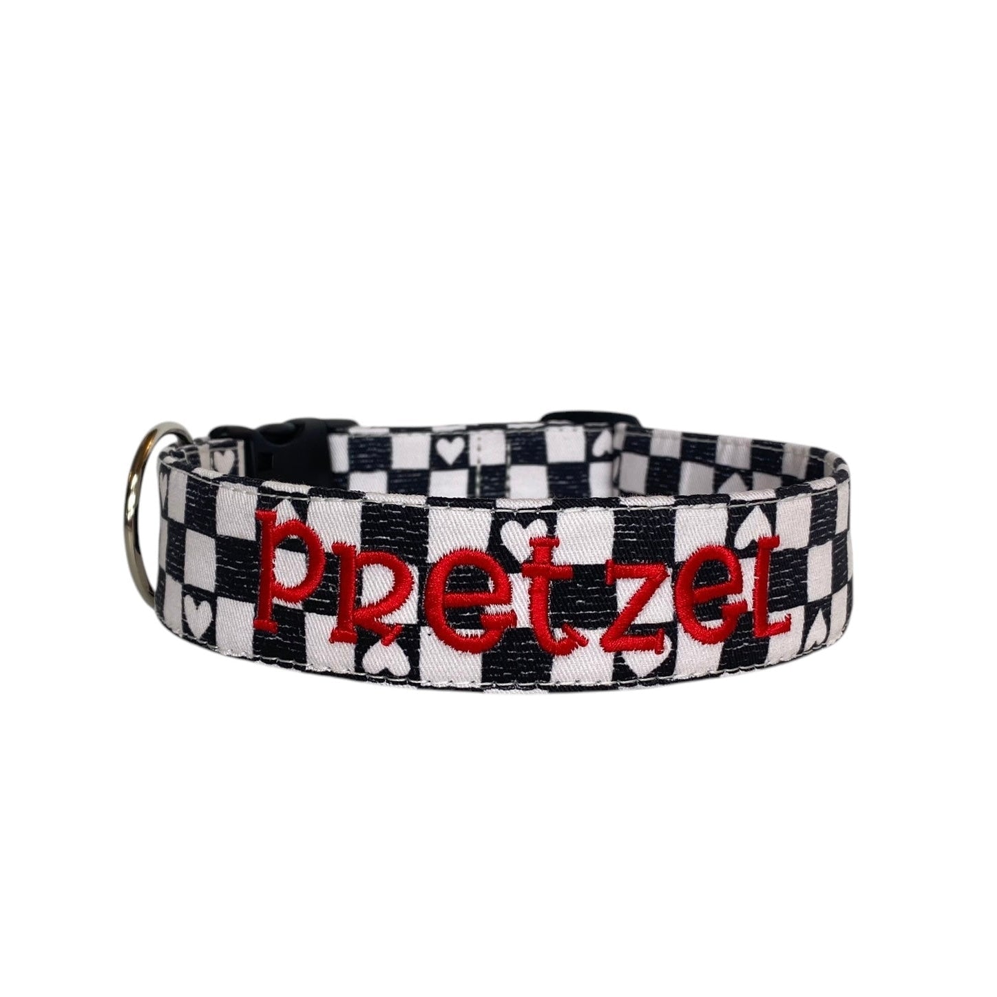 This personalized dog collar features a chic black-and-white checkered pattern with heart accents, making it a stylish choice for your pup. Embroidered with your pet’s name in bold red stitching, it’s both functional and fashionable. Complete with sturdy hardware, this collar is ideal for everyday use or special occasions. Perfect for dog owners seeking unique and customizable accessories for their furry friends!