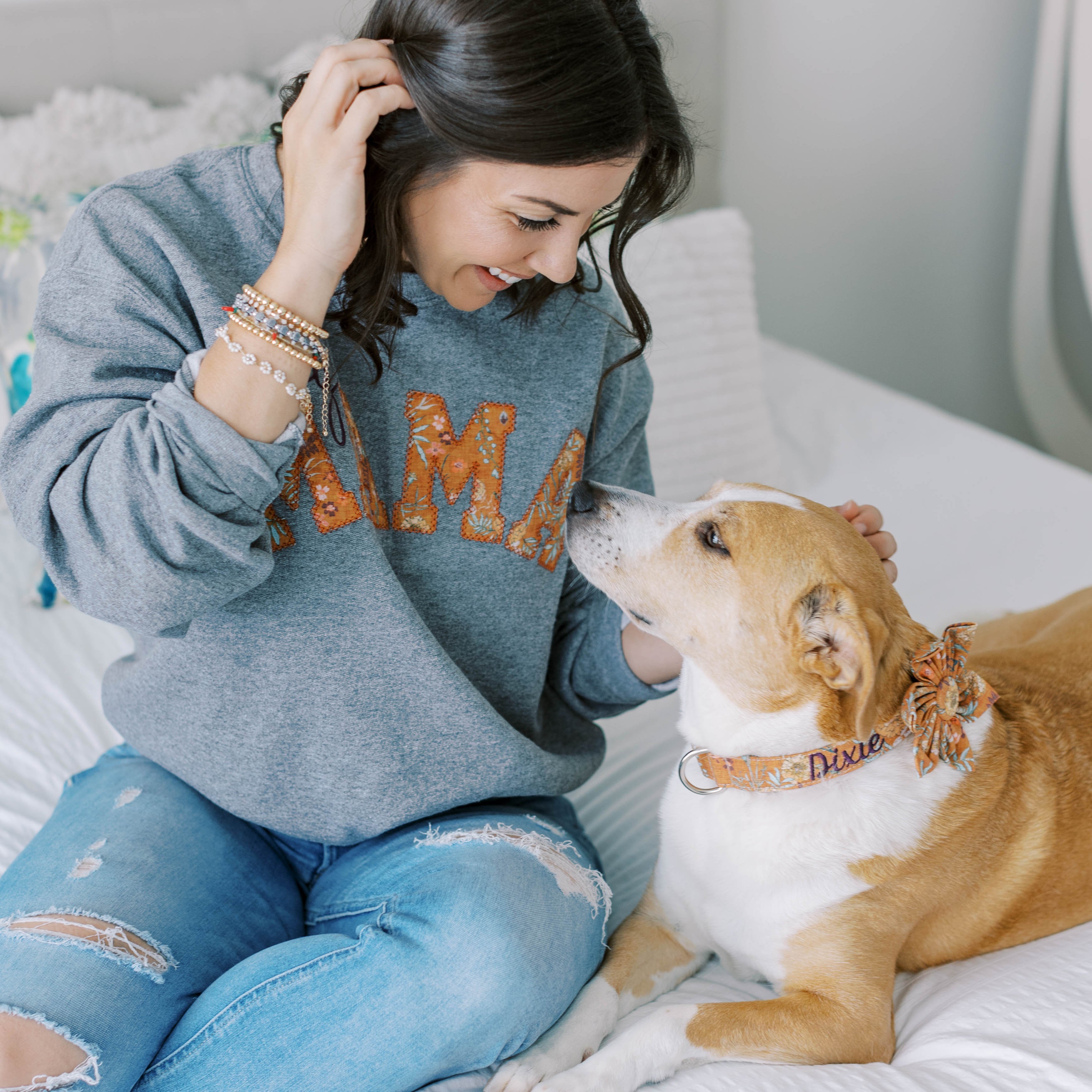 a model wearing Dog Mama Sweatshirt with her dog wearing a matching embroidered collar. Dog Mom sweatshirt with matching accessories.