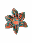 Dog collar flower with teal backdrop and vibrant pumpkins and leaves.
