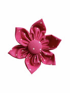 A pink flower with white polka dots and velcro backing to be put onto any dogs collar.