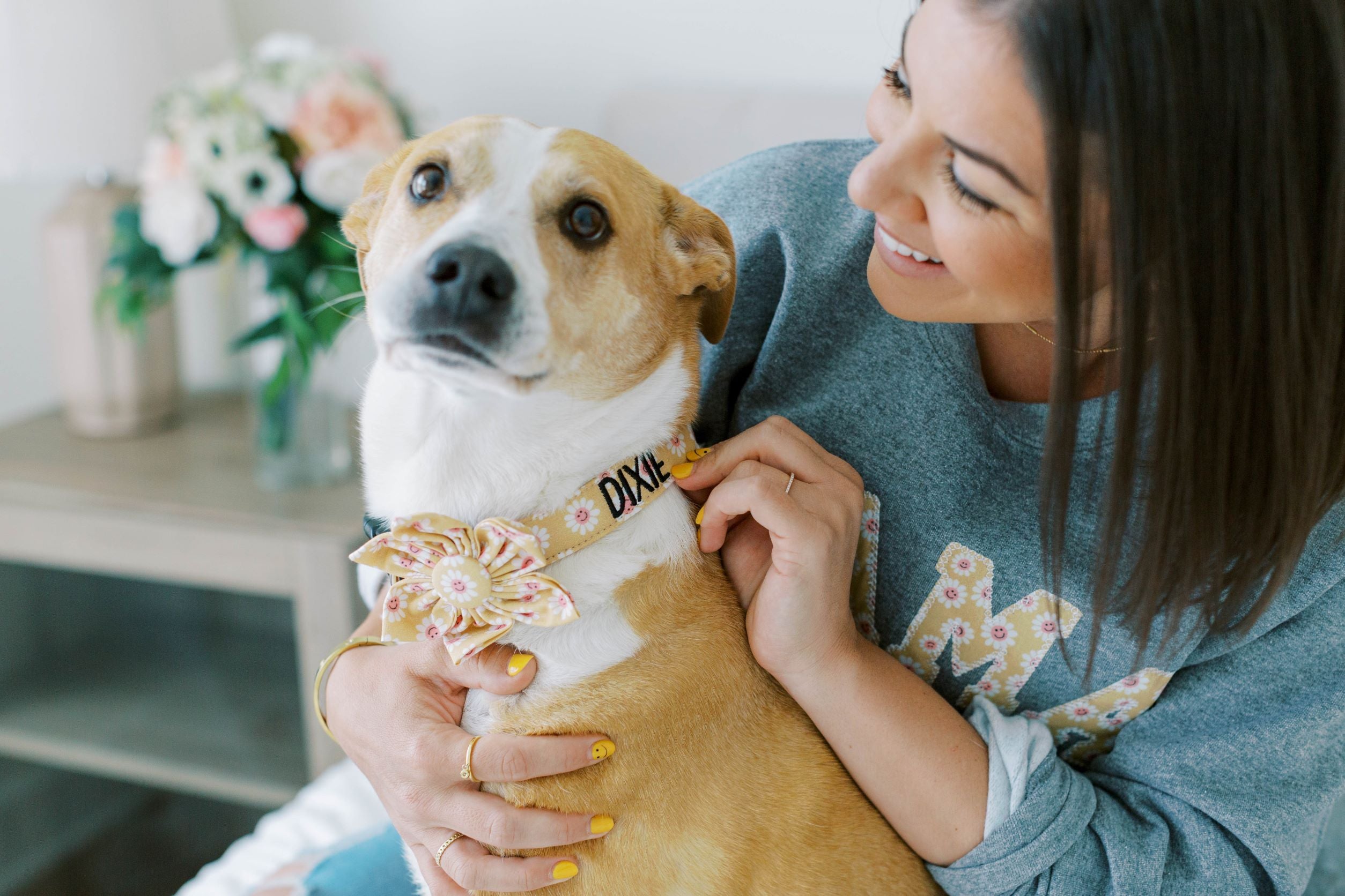 Model wearing dog mom sweatshirt with her dog in a matching personalized dog collar with flower collar accessory.